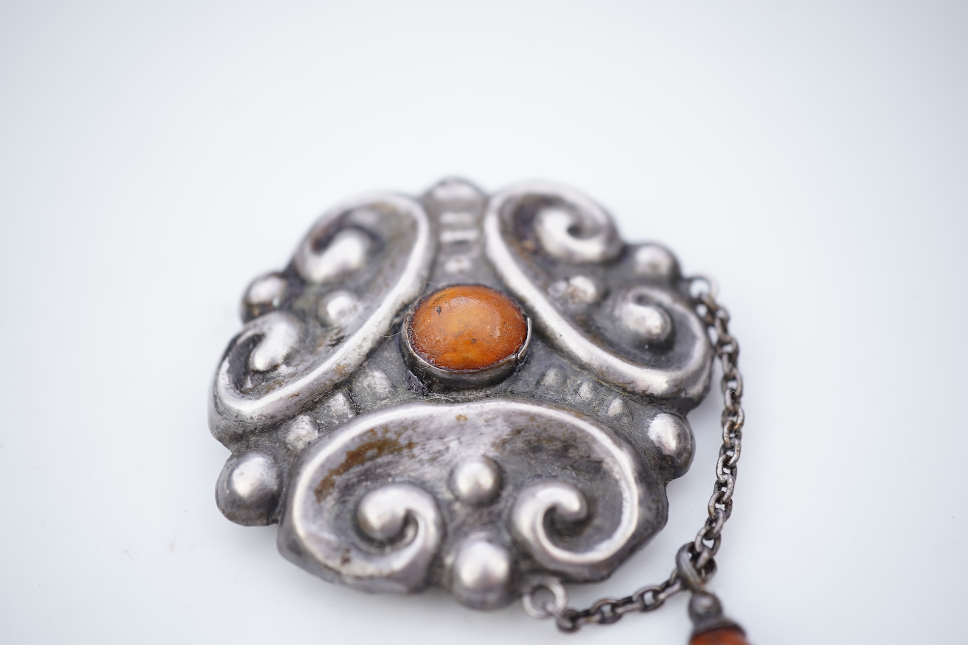 Two Arts & Crafts silver and amber pendant brooches, probably Denmark, early 20th century